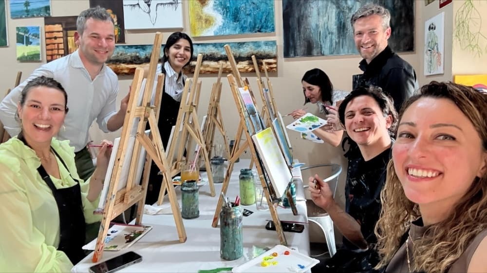 Group of people painting on small easles