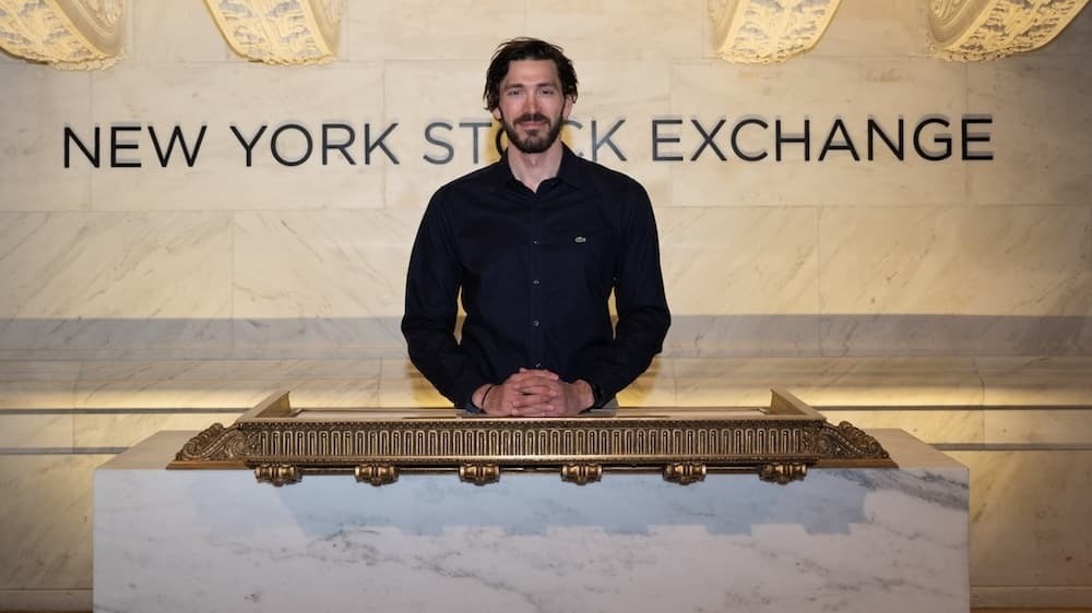 Man standing in front of NYSE sign