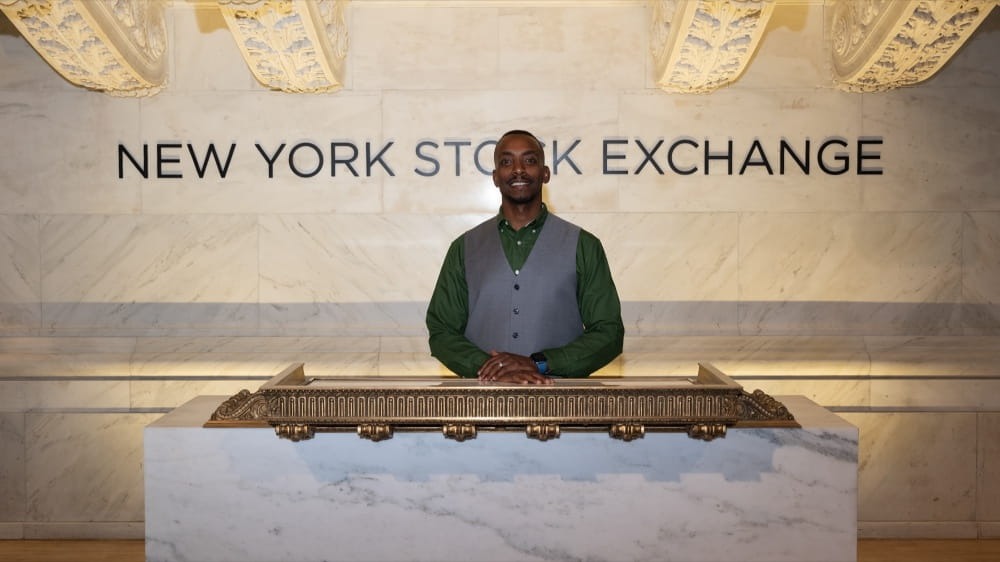 Man standing in front of NYSE sign